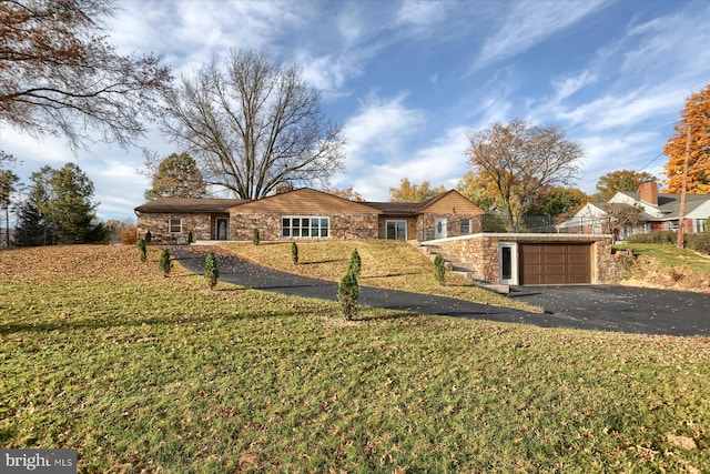 ranch-style house featuring a garage and a front yard