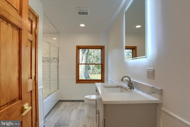 full bathroom with toilet, vanity, hardwood / wood-style floors, and combined bath / shower with glass door