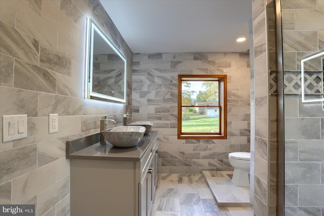 bathroom with vanity, tile walls, and toilet