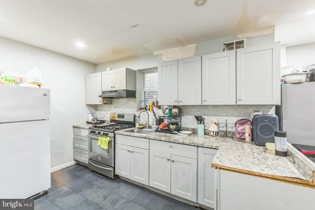 kitchen with white cabinets, gas range, sink, and white refrigerator