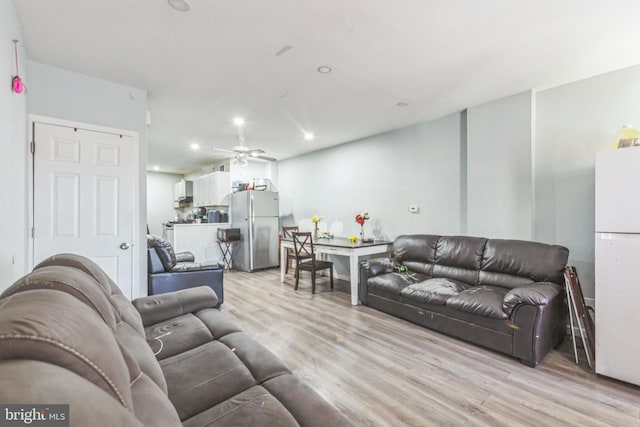 living room featuring ceiling fan and light hardwood / wood-style flooring