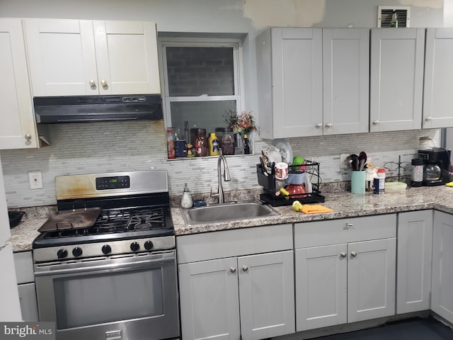 kitchen featuring white cabinets, stainless steel range with gas stovetop, sink, and range hood