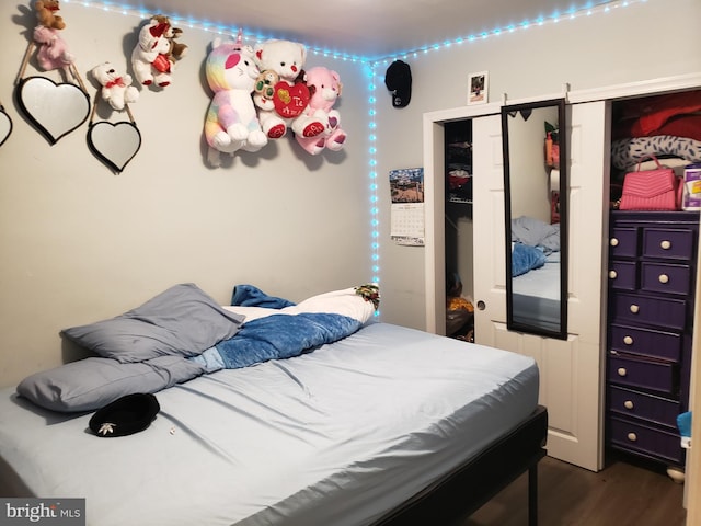 bedroom with dark wood-type flooring and a closet