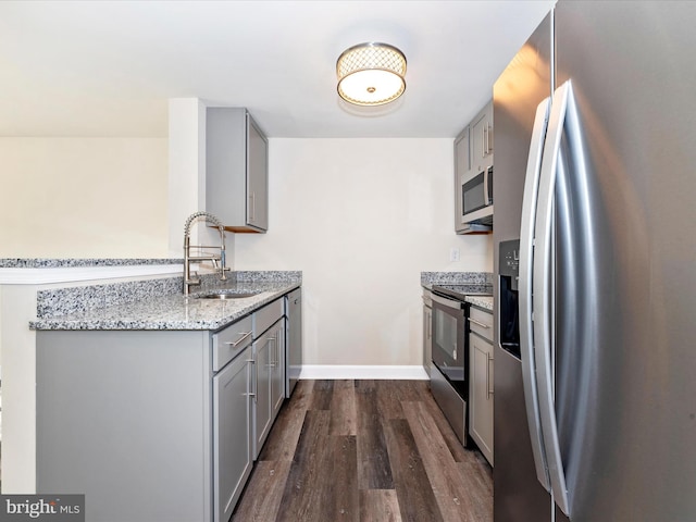 kitchen featuring gray cabinets, stainless steel appliances, dark hardwood / wood-style floors, and sink