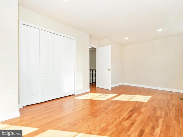 unfurnished bedroom featuring a closet and light wood-type flooring