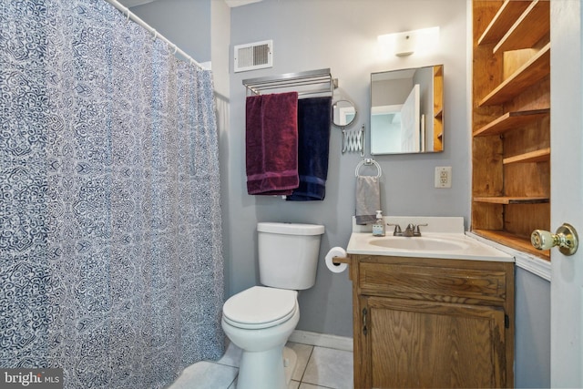 bathroom with toilet, vanity, and tile patterned flooring