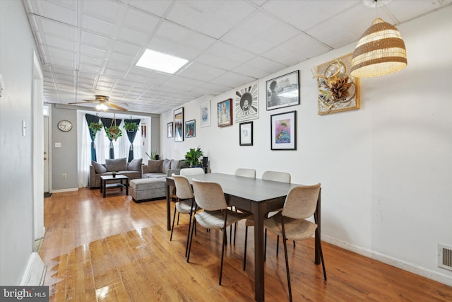 dining room with a paneled ceiling, ceiling fan, and light hardwood / wood-style floors