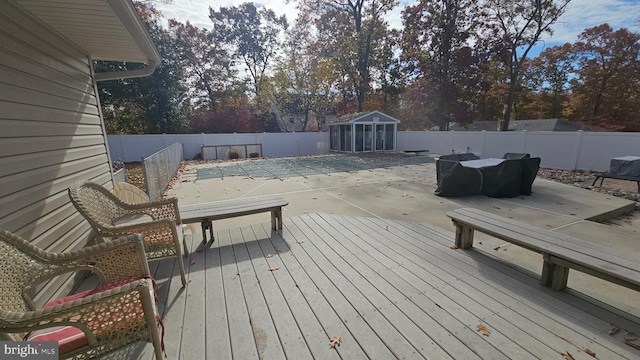 wooden terrace with an outbuilding and a covered pool