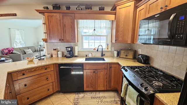 kitchen with sink, light stone counters, backsplash, light tile patterned flooring, and black appliances