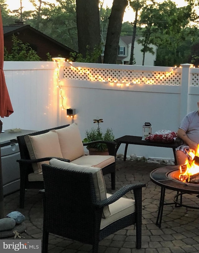 patio terrace at dusk featuring a fire pit