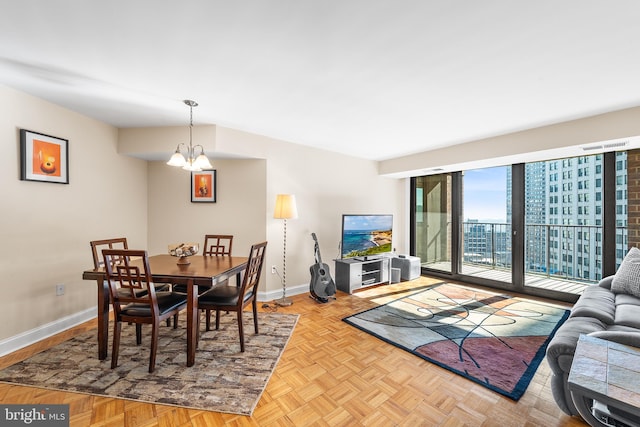 dining space featuring an inviting chandelier and light parquet flooring