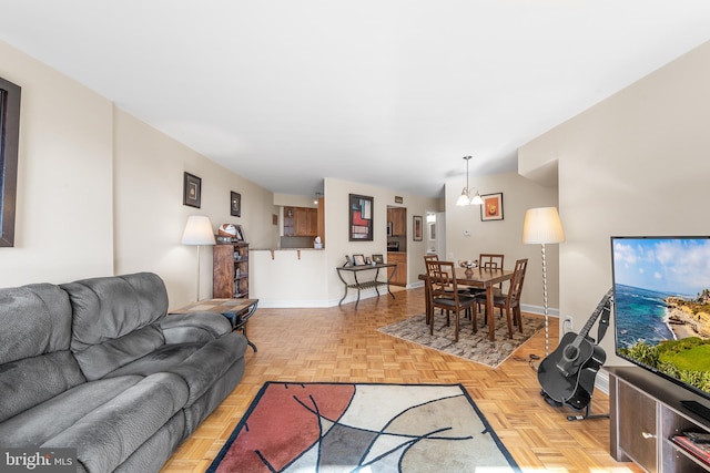 living room featuring light parquet flooring and a notable chandelier