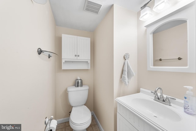 bathroom with toilet, vanity, and tile patterned floors