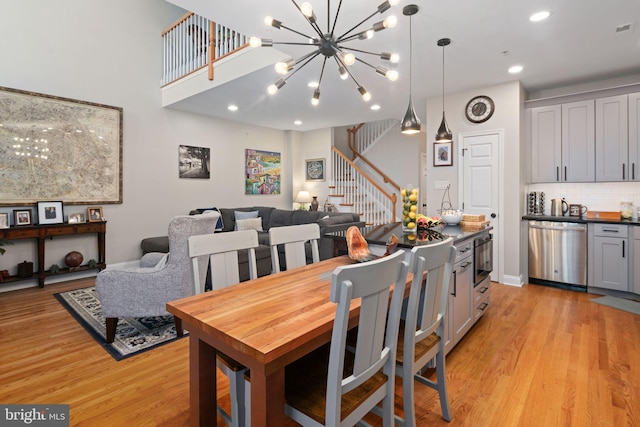 dining space featuring light wood-type flooring and a notable chandelier