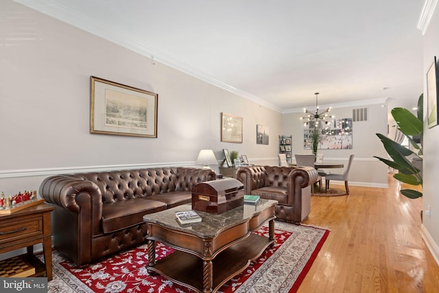 living room featuring light hardwood / wood-style floors, a chandelier, and crown molding