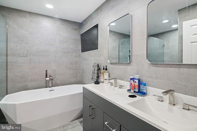 bathroom with vanity, tile walls, and a bathing tub