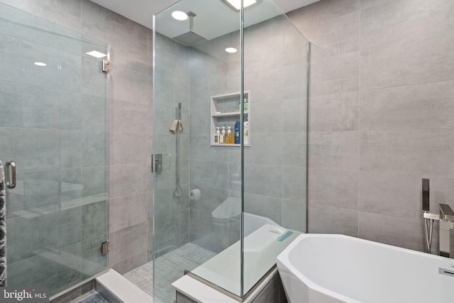 bathroom featuring separate shower and tub