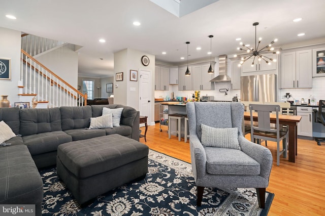 living room with light hardwood / wood-style flooring and a notable chandelier