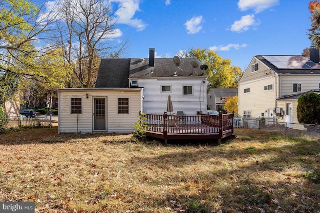 back of house featuring a lawn and a wooden deck