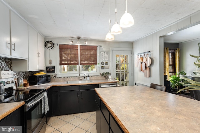kitchen with a sink, white cabinets, stainless steel range with electric cooktop, decorative backsplash, and black microwave