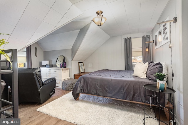 bedroom featuring wood finished floors and lofted ceiling