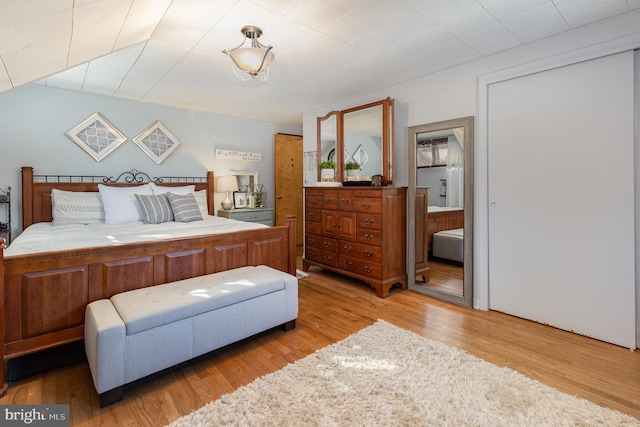bedroom with ensuite bath and wood finished floors