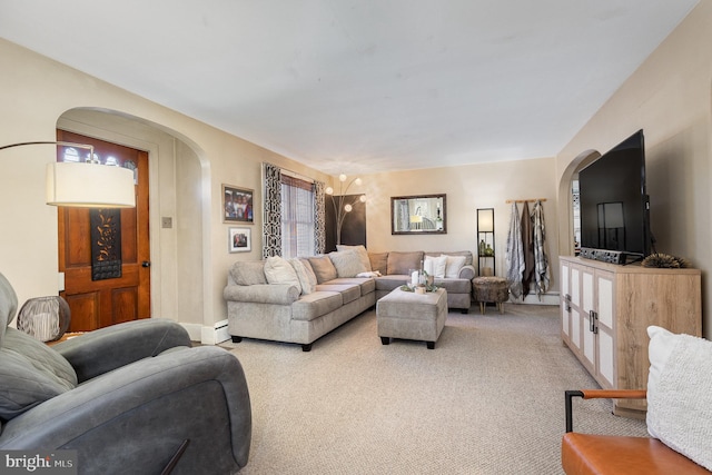 living area with arched walkways, baseboard heating, and light colored carpet
