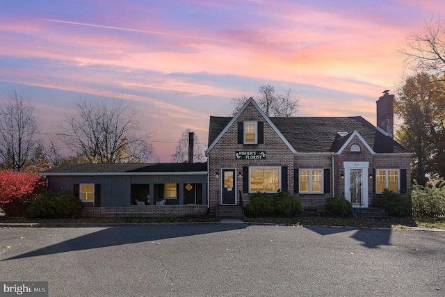 view of front of property with brick siding and a chimney