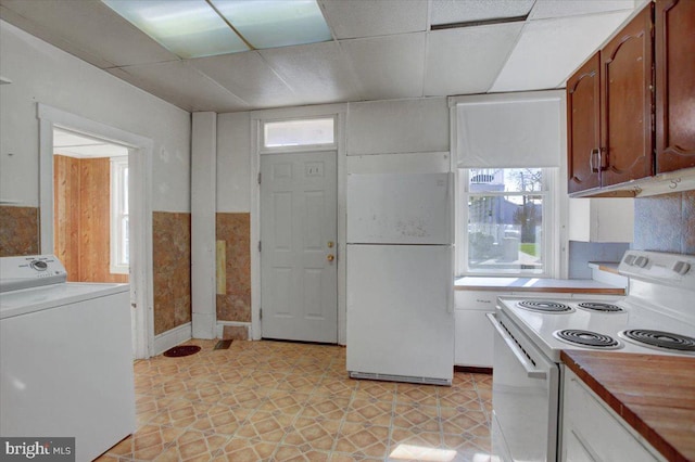 kitchen featuring light tile patterned flooring, white appliances, a paneled ceiling, and washer / clothes dryer