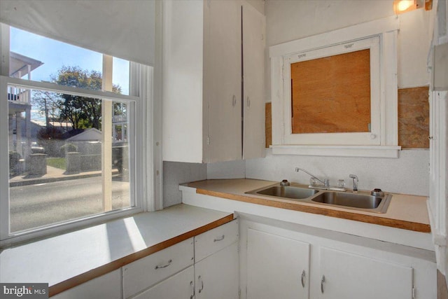 kitchen featuring white cabinets, plenty of natural light, and sink