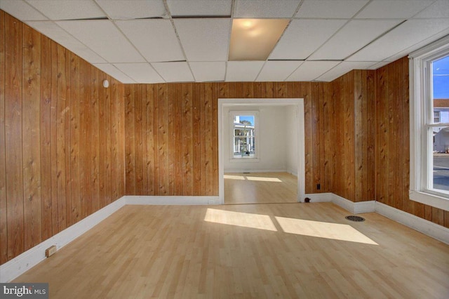 spare room featuring wood walls and light hardwood / wood-style floors