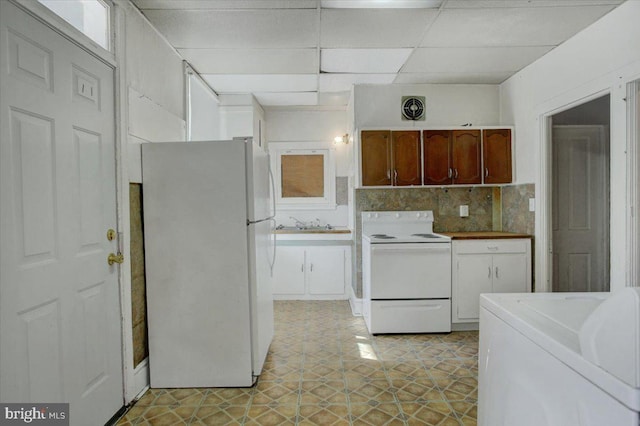 kitchen featuring a drop ceiling, tasteful backsplash, light tile patterned flooring, washer / clothes dryer, and white appliances