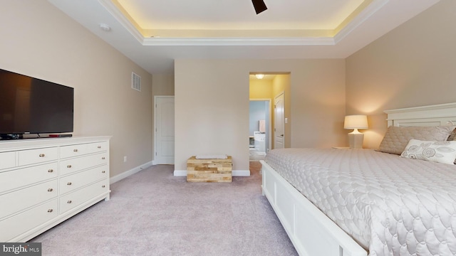 bedroom featuring ceiling fan, light colored carpet, and a tray ceiling