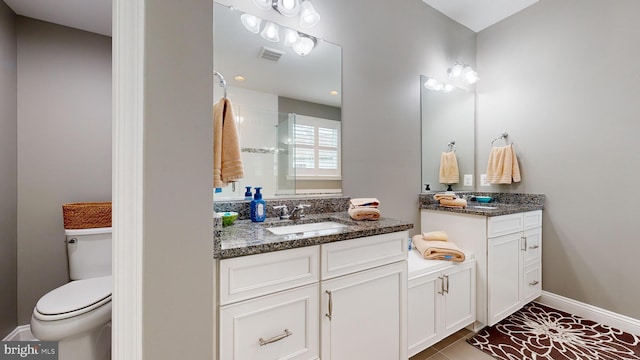 bathroom featuring toilet, vanity, and tile patterned flooring