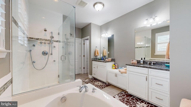 bathroom featuring vanity, tile patterned floors, and plus walk in shower