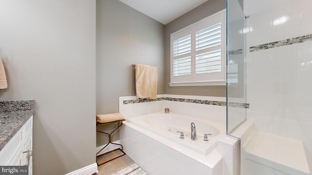 bathroom featuring plus walk in shower and vanity