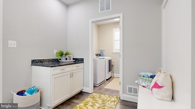 laundry area with dark wood-type flooring and independent washer and dryer