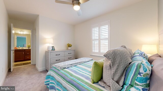 bedroom with ceiling fan, connected bathroom, and light colored carpet