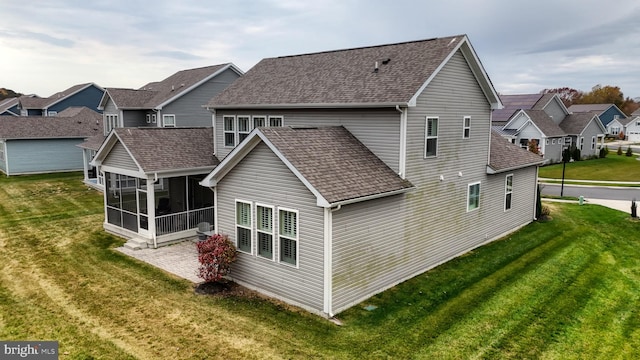 rear view of property with a sunroom and a yard