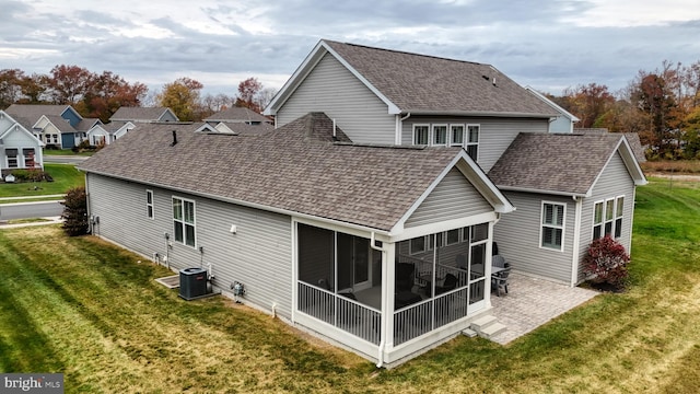 back of property featuring a lawn and a sunroom