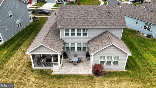 back of house featuring a patio, a sunroom, a lawn, and central air condition unit