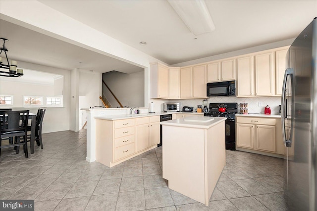 kitchen featuring light tile patterned flooring, black appliances, kitchen peninsula, backsplash, and a center island