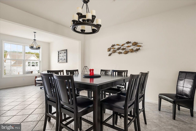 tiled dining area featuring a chandelier