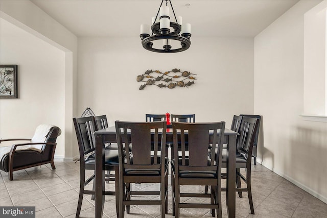 tiled dining room featuring a notable chandelier