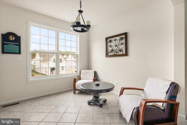 living area with light tile patterned floors and a chandelier