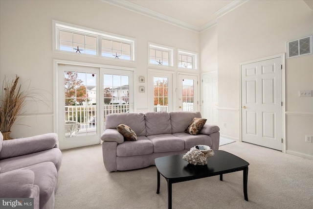 living room with ornamental molding, light carpet, and a high ceiling