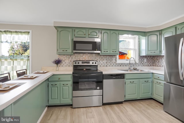 kitchen featuring light hardwood / wood-style flooring, backsplash, sink, and stainless steel appliances