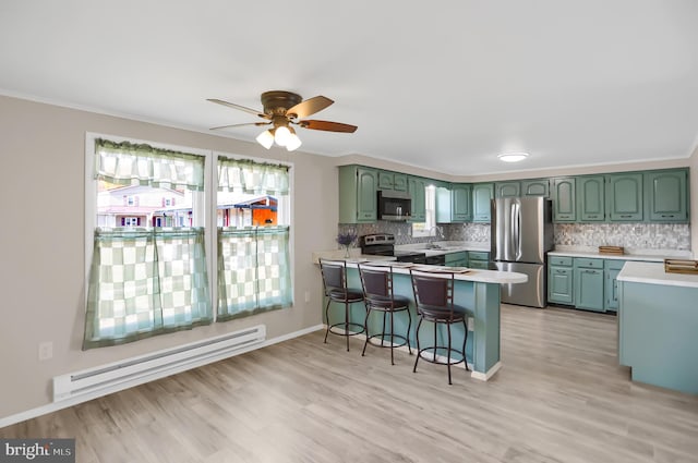 kitchen featuring a baseboard heating unit, kitchen peninsula, stainless steel appliances, and light hardwood / wood-style flooring