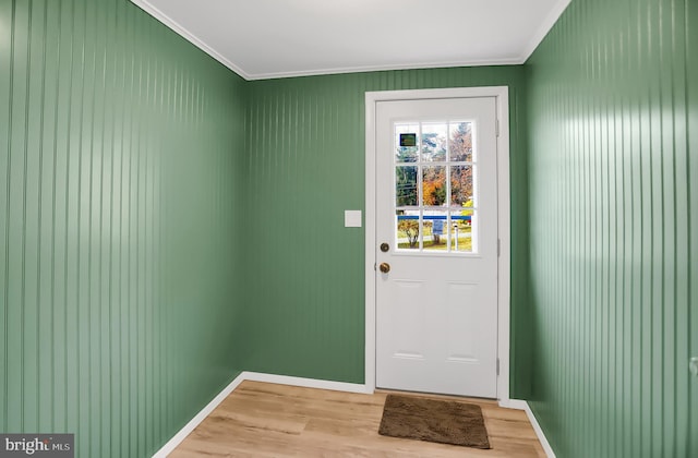 doorway featuring light wood-type flooring and crown molding