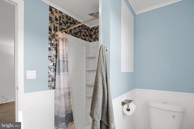 bathroom with a shower with shower curtain, toilet, and ornamental molding